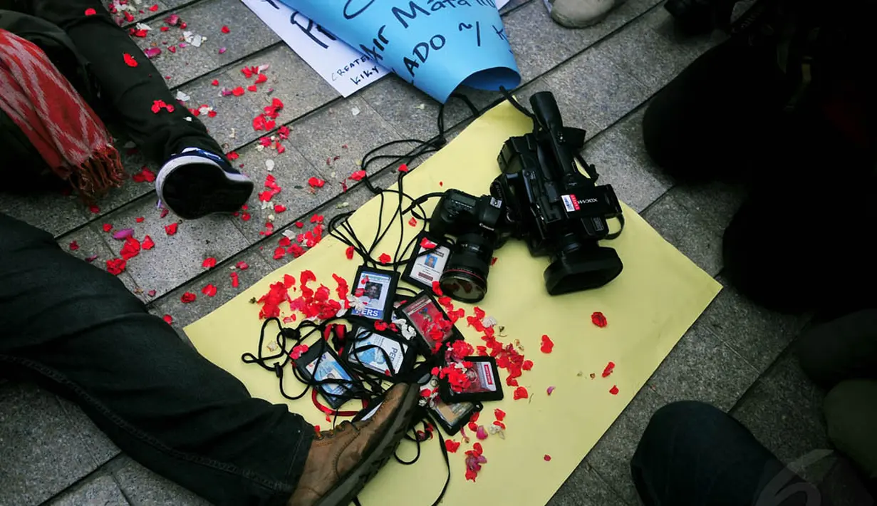 Sejumlah wartawan mengumpulkan ID Card, kamera, dan alat perekam saat berunjuk rasa di Bundaran HI, Jakarta, Jumat (14/11/2014). (Liputan6.com/Johan Tallo)
