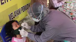 Petugas mengambil sampel lendir hidung untuk pemeriksaan tes swab antigen di Polsek Pamulang, Tangerang Selatan pada Rabu (19/5/2021). Swab antigen gratis itu bagi warga Pamulang yang sudah kembali usai menjalani perjalanan mudik untuk antisipasi penularan virus corona. (merdeka.com/Arie Basuki)