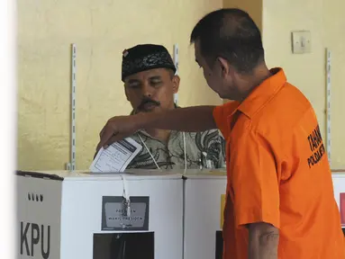 Tahanan memasukkan surat suara ke dalam kotak usai mencoblos di TPS 15 Rutan Polda Metro Jaya, Jakarta, Rabu (17/4). Sebanyak 538 tahanan di Rutan Polda Metro Jaya yang telah terdaftar dalam DPT ikut menyuarakan aspirasinya dalam Pemilu 2019. (Liputan6.com/Herman Zakharia)