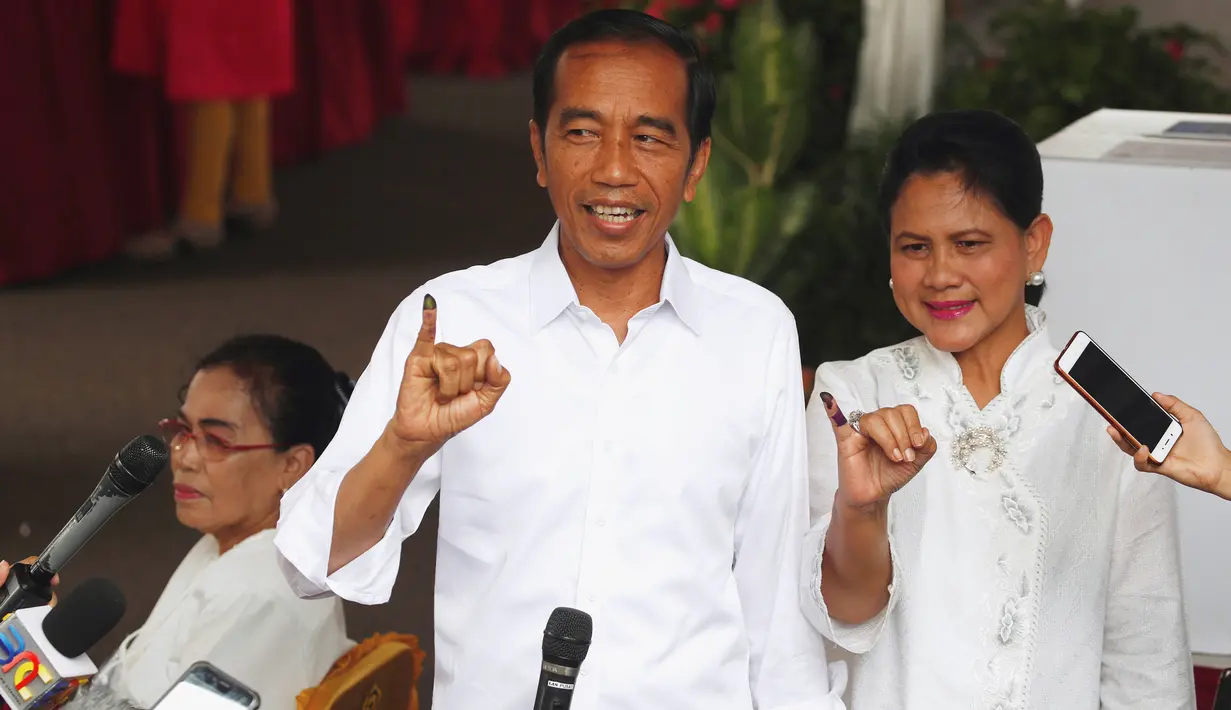 Capres nomor urut 01 Joko Widodo atau Jokowi dan istrinya, Iriana menunjukkan jari yang telah dicelup tinta usai melakukan pencoblosan dalam Pemilu 2019 di TPS 008 Gambir, Jakarta Pusat, Rabu (17/4). Jokowi dan Iriana terdaftar di nomor urut 154 dan 155 daftar DPT.	(REUTERS/Edgar Su)