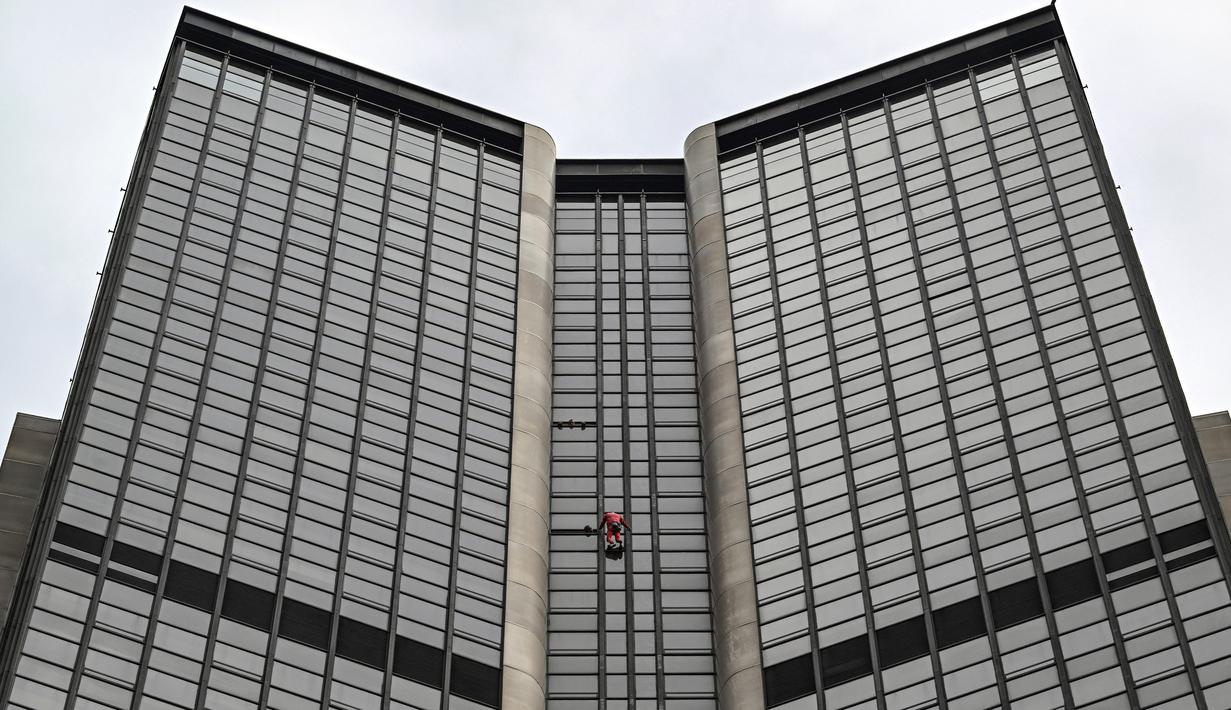 Alain Robert, pendaki bangunan pencakar langit asal Prancis memanjat Menara Montparnasse di Paris, Prancis, Rabu (12/10/2022). Alain Robert yang dikenal sebagai Spiderman Prancis itu kembali beraksi dengan memanjat Menara Montparnasse yang memiliki ketinggian 210 meter. (Bertrand GUAY/AFP)