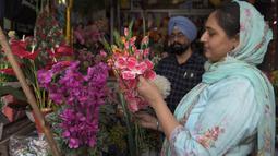 Seorang perempuan membeli bunga palsu menjelang festival Diwali di sebuah pasar di Amritsar, India pada 10 November 2020. Tahun ini festival lampu Diwali jatuh pada 14 November mendatang. (Photo by NARINDER NANU / AFP)