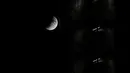 Fenomena gerhana bulan sebagian (parsial) terlihat di atas gedung pencakar langit di distrik EUR Roma di Italia pada Selasa (16/7/2019). Gerhana bulan parsial ini bisa diamati dari Amerika Selatan, Eropa, Afrika, Asia dan Australia. (Andreas SOLARO/AFP)