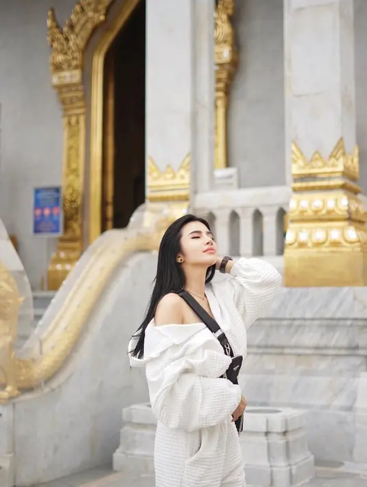 Berpose dengan tangan diangkat, Maria Vania terlihat begitu kece dengan memilih sling bag Prada berwarna hitam. Perpaduan warna outfit dan aksesoris yang match. (Instagram/maria_vaniaa)