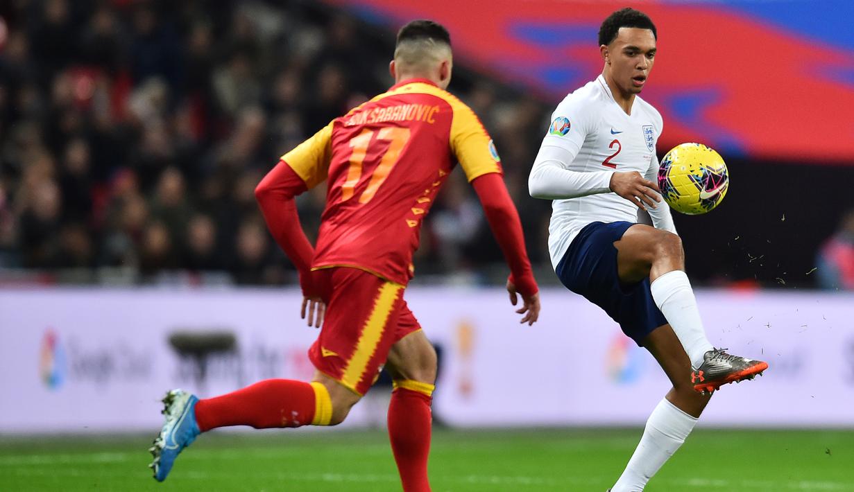Bek Inggris, Trent Alexander-Arnold berusaha mengontrol bola dari kawalan pemain Montenegro pada pertandingan Grup A Kualifikasi Piala Eropa 2020 di Stadion Wembley di London (14/11/2019). Inggris menang telak 7-0 atas Montenegro. (AFP/Glyn Kirk)