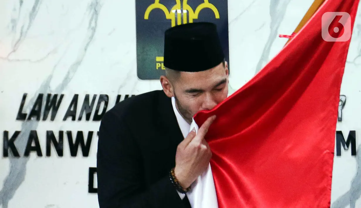 Pemain sepak bola Sandy Walsh mencium bendera Merah Putih usai menjalani Sumpah Janji Setia Pewarganegaraan di Kantor Wilayah Kementerian Hukum dan HAM DKI Jakarta, Kamis (17/11/2022). Sandy Walsh resmi menjadi Warga Negara Indonesia (WNI) setelah prosesi pengambilan sumpah yang digelar secara tertutup. (Liputan6.com/Herman Zakharia)
