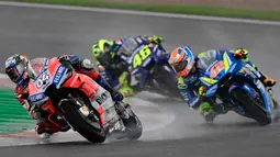 Pebalap Ducati, Andrea Dovizioso (kiri) disusul pebalap Movistar Yamaha, Valentino Rossi dan pebalap Suzuki, Alex Rins saat balapan MotoGP Grand Prix Valencia di arena balapan Ricardo Tormo, Cheste, Minggu (18/11). (Jose Jordan/AFP)