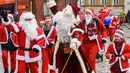 Peserta mengambil bagian dalam Santa's Fun Run di Riga, Latvia, Minggu (8/12/2019). Ini merupakan acara amal yang pesertanya bersenang-senang dengan berlari atau berjalan kaki sambil mengenakan kostum Sinterklas untuk mengumpulkan dana bagi anak-anak di rumah sakit Latvia. (Gints Ivuskans/AFP)