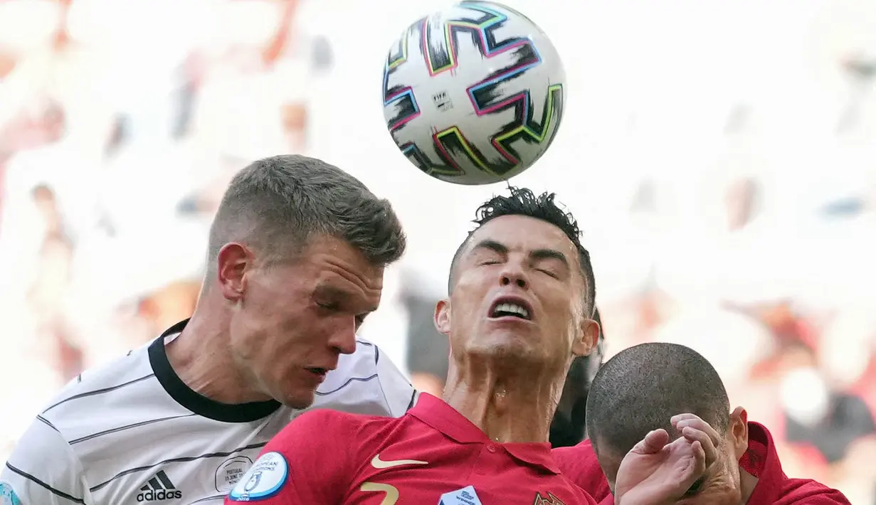 Pemain Timnas Portugal Cristiano Ronaldo (kanan) melakukan duel udara dengan pemain Timnas Jerman Matthias Ginter pada pertandingan Grup F Euro 2020 antara Portugal melawan Jerman di Allianz Arena, Munich, Sabtu (19/6/2021). (Foto: AFP/Pool/Matthias Schrader)