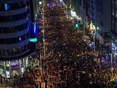 Ribuan orang berbaris menuju jalan Gran Via saat memperingati Hari Perempuan Internasional di Madrid (8/3). Mereka berkumpul dan melakukan aksi mogok untuk  hak-hak perempuan. (AFP/Oscar Del Pozo)