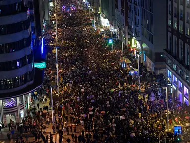 Ribuan orang berbaris menuju jalan Gran Via saat memperingati Hari Perempuan Internasional di Madrid (8/3). Mereka berkumpul dan melakukan aksi mogok untuk  hak-hak perempuan. (AFP/Oscar Del Pozo)