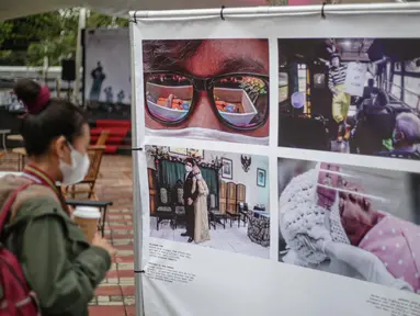 Pengunjung mengamati karya Pameran Fotografi Rekam Jakarta 2019-2020 di Thamrin 10, Jakarta, Jumat (4/12/2020). Pameran yang mengangkat tema Ragam Cerita Ibu Kota Sebelum dan Saat Pandemi COVID-19 tersebut berlangsung hingga 13 Desember 2020. (Liputan6.com/Faizal Fanani)