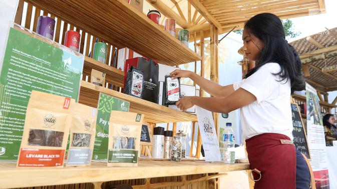 SPG merapikan produk Teh Sila dan Kopi Rollaas milik Holding Perkebunan Nusantara (PTPN Group) yang dipamerkan Indonesia Pavilion saat  IMF-World Bank 2018, Nusa Dua, Bali, Kamis (11/10). (Liputan6.com/Angga Yuniar)