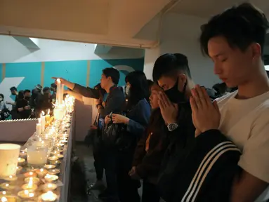 Para pengunjuk rasa berdoa di lokasi di mana mahasiswa Alex Chow Tsz-lok jatuh selama protes baru-baru ini di Hong Kong pada hari Jumat, (8/11/2019). Chow, seorang mahasiswa universitas Hong Kong  jatuh dari tempat parkir setelah polisi menembakkan gas air mata saat bentrokan. (AP Photo/Kin Cheung)