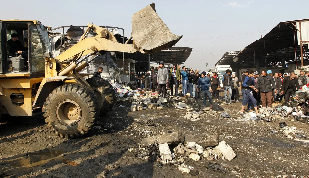 Buldoser digunakan untuk mengevakuasi puing-puing bekas ledakan bom di pasar sayur Jumila di Baghdad, Irak (8/1). Sejauh ini belum ada pihak yang mengaku bertanggung jawab atas serangan yang menghantam pasar di Baghdad itu. (AFP/Sabar Arar)