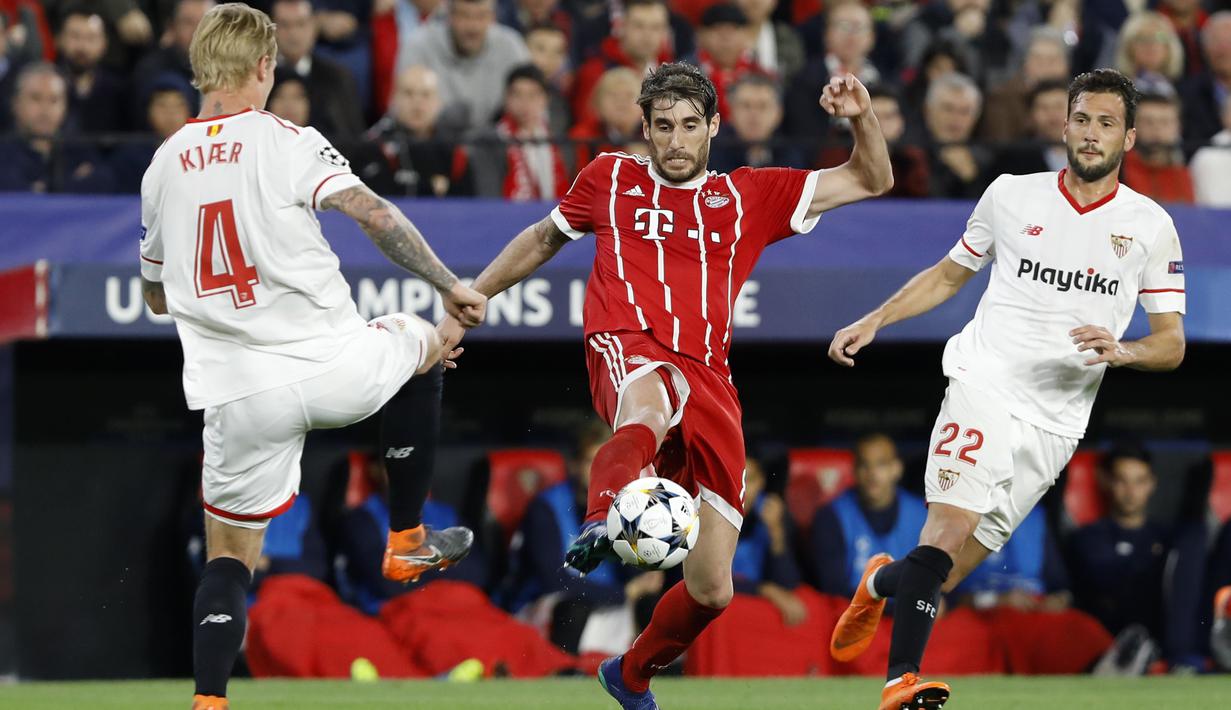 Aksi pemain Bayern, Javi Martinez (tengah) berusaha melewati adangan dua pemain Sevilla pada leg pertama Liga Champions di Sanchez Pizjuan stadium, Seville, (3/4/2018) waktu setempat. Beyern menang 2-1. (AP/Miguel Morenatti)