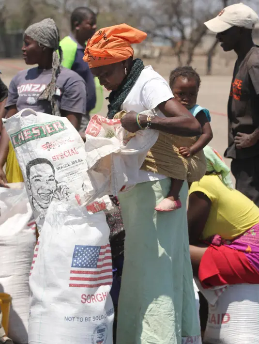 Seorang wanita mengambil bantuan makanan dari World Food Programme di Chiredzi Mupinga, Zimbabwe, Selasa (6/10). Puluhan juta orang di wilayah sub-Sahara Afrika akan mengalami kelaparan akibat siklus El Nino mencapai puncaknya. (REUTERS/Philimon Bulawayo)