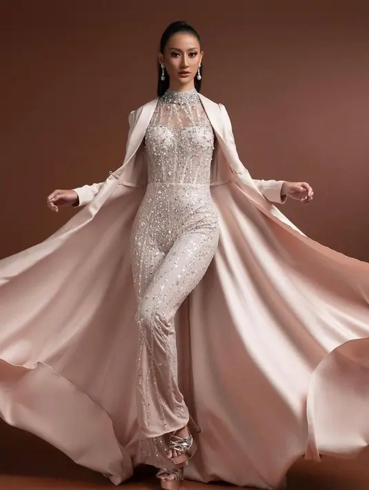 Jumpsuit berhiaskan brokat dan payet warna putih akan terlihat semakin glamor dan elegan dengan ditambah item fashion seperti kardigan satin. (Instagram/ayumaulida).