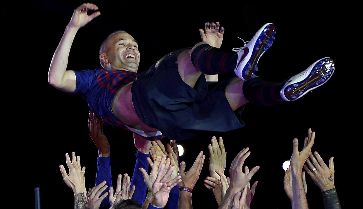 Gelandang Barcelona, Andres Iniesta, diangkat rekan-rekannya usai melawan Real Sociedad pada laga La Liga Spanyol di Stadion Camp Nou, Barcelona, Minggu (20/5/2018). Dirinya berpisah dengan klub yang 22 tahun telah dibela. (AFP/Lluis Gene)