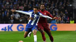 Penyerang Liverpool, Dovick Origi berduel dengan Eder Militao pada leg kedua babak perempat final Liga Champions yang berlangsung di Stadion do Dragao, Porto, Kamis (17/4). Liverpool menang 4-1 atas Porto. (AFP/Miguel Riopa)