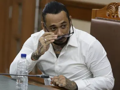 Musisi I Gede Ari Astina alias Jerinx SID sesaat sebelum sidang pembacaan putusan kasus dugaan pengancaman terhadap Adam Deni di PN Jakarta Pusat, Kamis (24/2/2022). I Gede Ari Astina divonis satu tahun penjara, denda Rp 25 juta subsider satu bulan kurungan. (Liputan6.com/Helmi Fithriansyah)