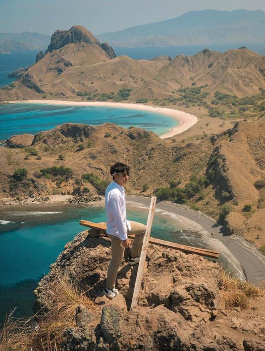 Berada di puncak Pulau Padar, foto bintang film Serendipity ini bikin iri. Pasalnya aktor berusia 30 tahun ini bisa menikmati keindahan laut dan gunung langsung dari puncak Pulau Padar. Laut yang berwarna biru dan hamparan gunung warna cokelat terlihat seperti lukisan saking indahnya. (Liputan6.com/IG/@kennyauztin)
