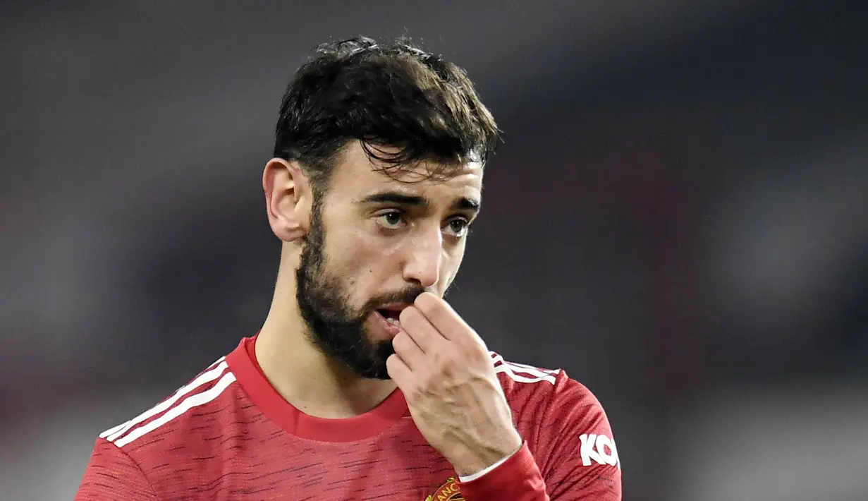 Gelandang Manchester United, Bruno Fernandes, gigit jari usai ditaklukkan Manchester City pada laga Piala Liga Inggris di Stadion Old Trafford, Rabu (6/1/2021). City menang dengan skor 2-0. (Peter Powell/Pool via AFP)