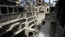 Orang-orang mandi di sumur tangga Bansilalpet berusia abad ke-18 yang sedang menjalani pekerjaan restorasi di Secunderabad, kota kembar Hyderabad, India (24/8/2022). (AFP/Noah Seelam)
