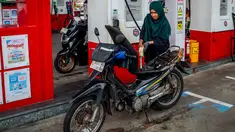 Seorang pengendara sepeda motor mengisi bahan bakar motornya di sebuah Stasiun Pengisian Bahan Bakar Umum (SPBU) yang dioperasikan oleh Pertamina, perusahaan minyak dan gas milik negara Indonesia, di Yogyakarta, pada Sabtu 28 Maret 2026. Konflik antara Iran dengan Amerika Serikat–Israel serta pembatasan di jalur strategis Selat Hormuz berdampak pada lonjakan harga minyak global. (DEVI RAHMAN/AFP)