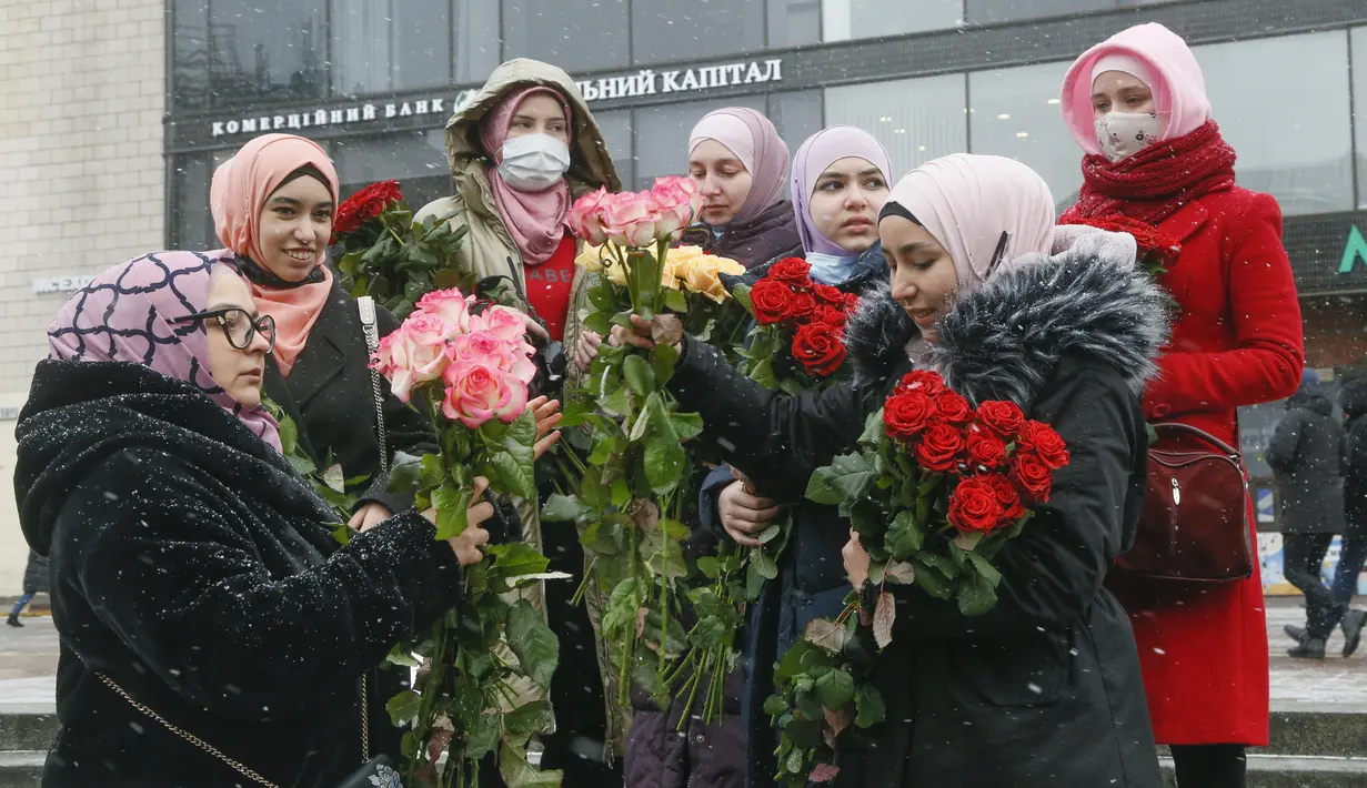 Aktivis berhijab memegang bunga saat memperingati Hari Hijab Sedunia di Kyiv, Ukraina, Senin (1/2/2021). Hari Hijab Sedunia diperingati setiap tanggal 1 Februari untuk menunjukkan solidaritas dengan wanita Muslim yang mengalami diskriminasi untuk mengenakan hijab. (AP Photo/Efrem Lukatsky)