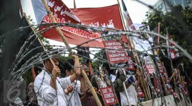 Para massa membawa poster kecaman saat menggelar aksi unjuk rasa di depan Istana Merdeka, Jakarta, Kamis (24/11). Dalam aksinya mereka mengecam keras pembunuhan kaum minoritas muslim di Rohingya, Myanmar. (Liputan6.com/Faizal Fanani)