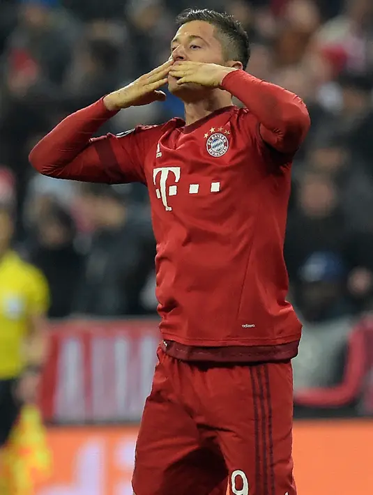 Penyerang Muenchen, Robert Lewandowski melakukan selebrasi usai mencetak gol kegawang Juventus pada leg kedua 16 besar liga champions di Stadion Allianz Arena, Jerman, Kamis (17/3). Muenchen menang atas Juventus dengan skor 4-2. (AFP/Tobias Schwarz)