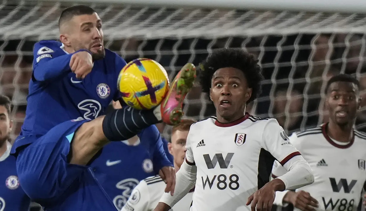 Penyerang Fulham, Willian terlihat saat gelandang Chelsea Mateo Kovacic menembak bola pada laga tunda pekan ke-7 Premier League 2022/2023 di Craven Cottage, Jumat (13/1/2023) WIB.  Chelsea kembali meraih hasil buruk di ajang Liga Inggris. (AP Photo/Alastair Grant)