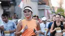 Rini Yulianti tampil mengenakan atasan tanpa lengan warna orange dipadukan celana pendek putih serasi dengan sepatu lari, kaos kaki panjang, dan topinya. [@riniyulianti]