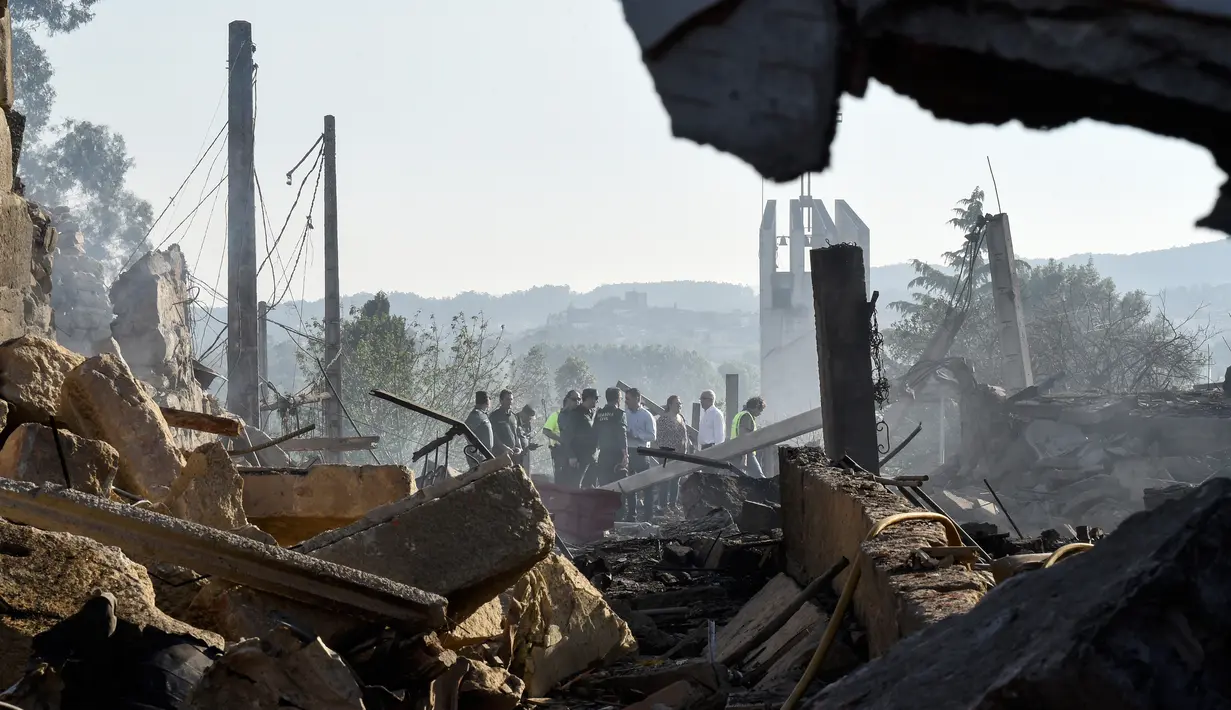 Petugas keamanan memeriksa area yang terkena ledakan gudang kembang api di Tui, Spanyol, Rabu (23/5). Satu orang tewas dalam kejadian tersebut. (MIGUEL RIOPA/AFP)