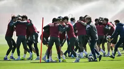 Latihan ini sebagai persiapan berlaga melawan Sporting CP di pertandingan leg pertama perempat final Liga Champions 2025/2026. Tampak dalam foto, para pemain berusaha membawa bola tanpa menjatuhkannya saat mengikuti sesi latihan tim di pusat pelatihan Arsenal di London Colney, utara London, pada Senin 6 April 2026. (Glyn KIRK/AFP)