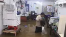 Seorang pria berada di dalam tokonya yang terendam banjir di Kawasan Bendungan Hilir (Benhil), Jakarta Pusat,  Selasa (25/2/2020). Salah satu wilayah terdampak banjir yakni kawasan Benhil hingga membuat akses jalan untuk sementara terputus.  (Liputan6.com/Angga Yuniar)