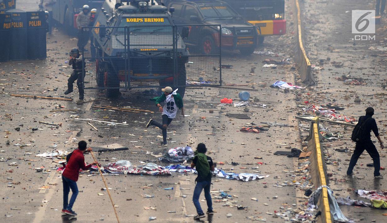 Polisi menembakkan gas air mata ke arah mahasiswa saat demonstrasi menolak pengesahan RUU KUHP dan revisi UU KPK di depan Gedung DPR, Jakarta, Selasa (24/9/2019). Polisi menghalau mahasiswa yang berusaha masuk ke area Gedung DPR. (merdeka.com/Arie Basuki)