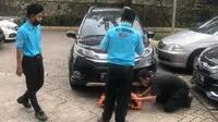 Petugas berusaha menggeser mobil parkir paralel yang mengganggu. (Source: Instagram/@parkirlobangsat)