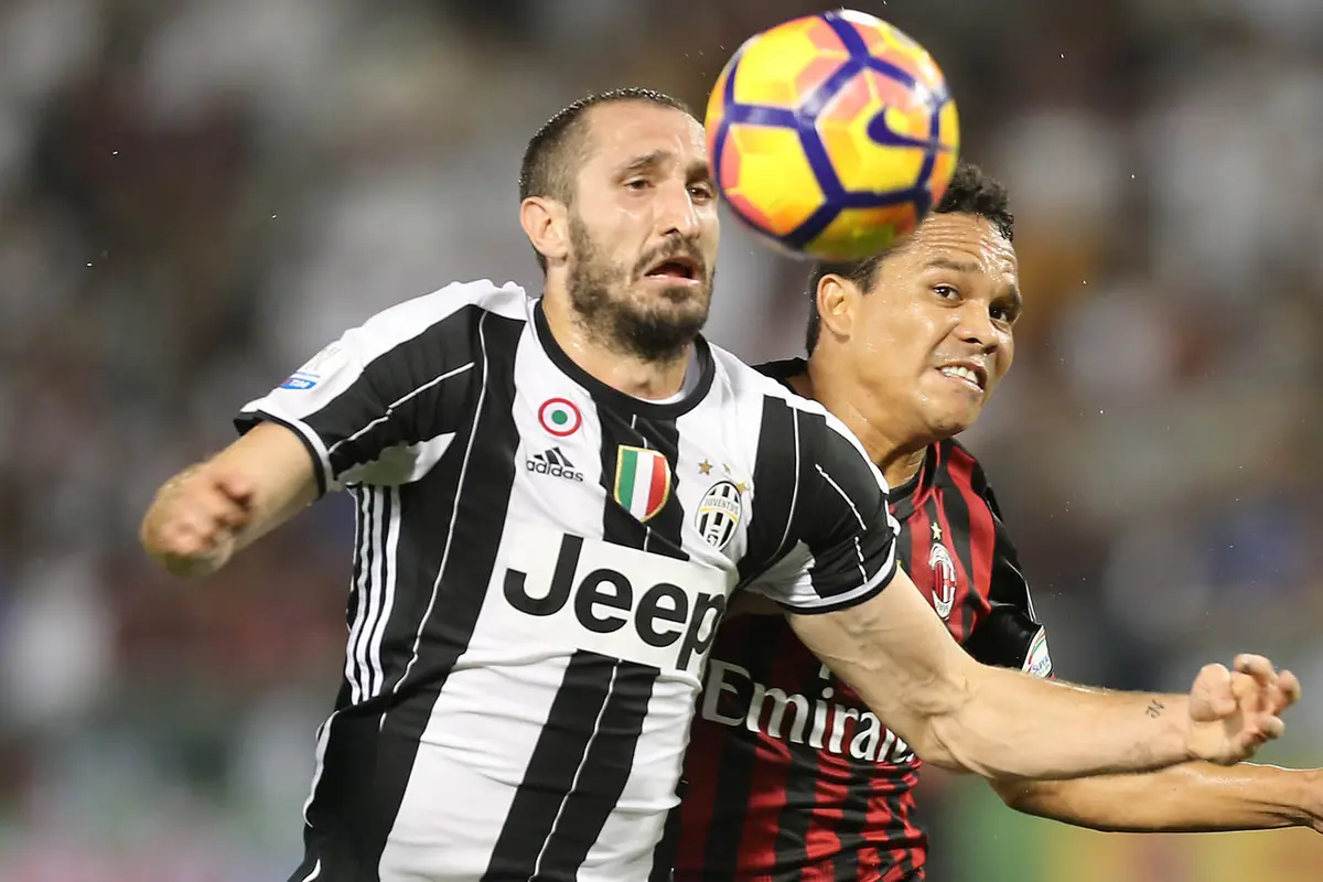 Bek Juventus, Giorgio Chiellini, duel udara dengan striker AC Milan, Carlos Bacca, pada laga Piala Super Italia 2016. Pada laga ini Juventus sebagai pemuncak klasemen Serie A lebih diunggulkan untuk meraih gelar. (AFP/Karim Jaafar)