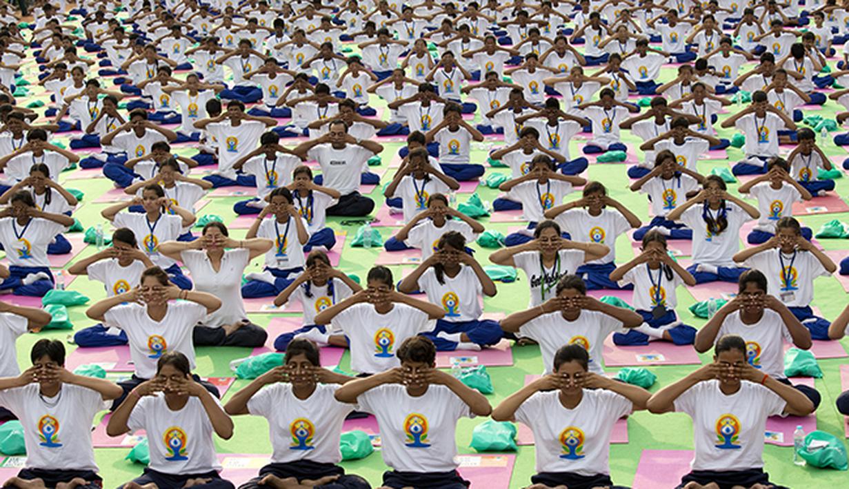 Puluhan ribu orang berpartisipasi melakukan gerakan yoga di New Delhi, India. (AP Photo/ Manish Swarup)