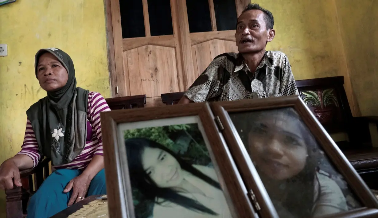 Ahmad Kaliman dan Suratmi orang tua dari Sumarti Ningsih, seorang wanita Indonesia yang dibunuh oleh Rurik Jutting Karyawan Bank of America Merrill Lynch di Hong Kong di desa mereka di Cilacap, Jawa Tengah , Indonesia (8/11). (REUTERS/Idhad Zakaria)