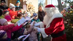 Seorang pria berpakaian Santa Claus disambut anak-anak selama pembukaan kantor surat Natal yang paling terkenal di Himmelpfort, Kamis (14/11/2019). Seperti tahun-tahun sebelumnya pada Natal kali ini Santa Klaus di Jerman sangat sibuk. (Soeren Stache/dpa via AP)