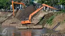 Dua alat berat melakukan pengerukan tumpukan sisa lumpur dan tanah yang menumpuk di pinggir kali Ciliwung, Jakarta, Kamis (28/7). Dinas Tata Air DKI Jakarta bersihkan tumpukan tanah dan lumpur sisa pengerukan kali Ciliwung. (Liputan6.com/Yoppy Renato)