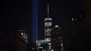 'Tribute in Light'  dinyalakan untuk memperingati serangan gedung kembar WTC yang terlihat di dekat gedung One World Trade Center, New York City, Selasa (10/9/2019). Cahaya kembar itu jadi simbol menara kembar WTC yang hancur diserang kelompok pembajak pesawat 18 tahun silam. (Johannes EISELE/AFP)