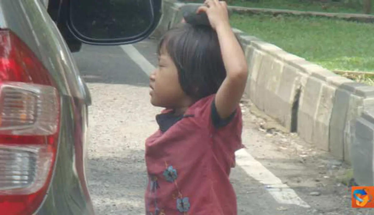 Citizen6, Bandung: Seorang anak sedang menawarkan cobeknya sambil mengemis ke pengendara mobil di lampu merah, Jl. Seram, Bandung