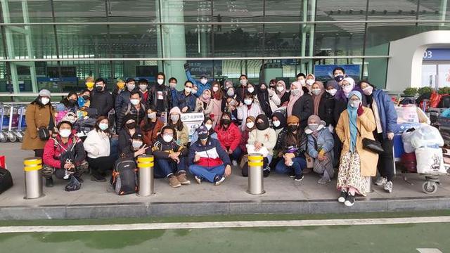 Sejumlah Warga Negara Indonesia (WNI) yang akan dievakuasi berpose bersama di Bandara Internasional Tianhe, Wuhan, Hubei, China, Sabtu, (1/2/2020).