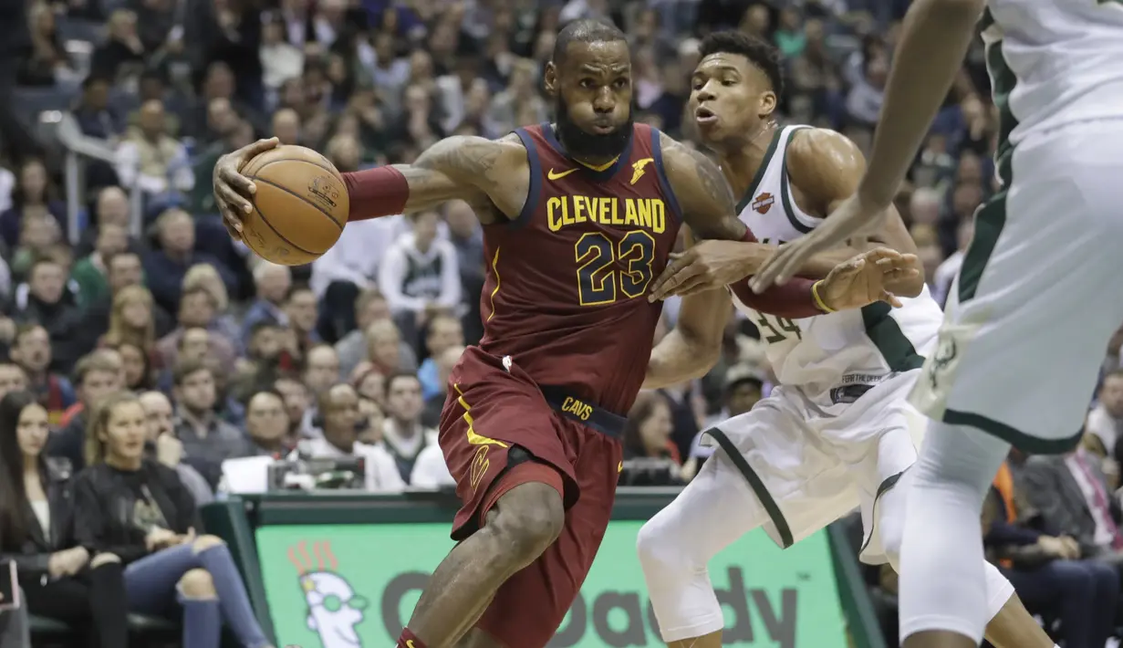 Pemain Cleveland Cavaliers, LeBron James (kiri) menggiring bola melewati adangan pemain Milwaukee Bucks, Giannis Antetokounmpo pada laga NBA basketball game di BMO Harris Bradley Center, Milwaukee, (19/12/2017). Bucks menang 119-116. (AP/Morry Gash)