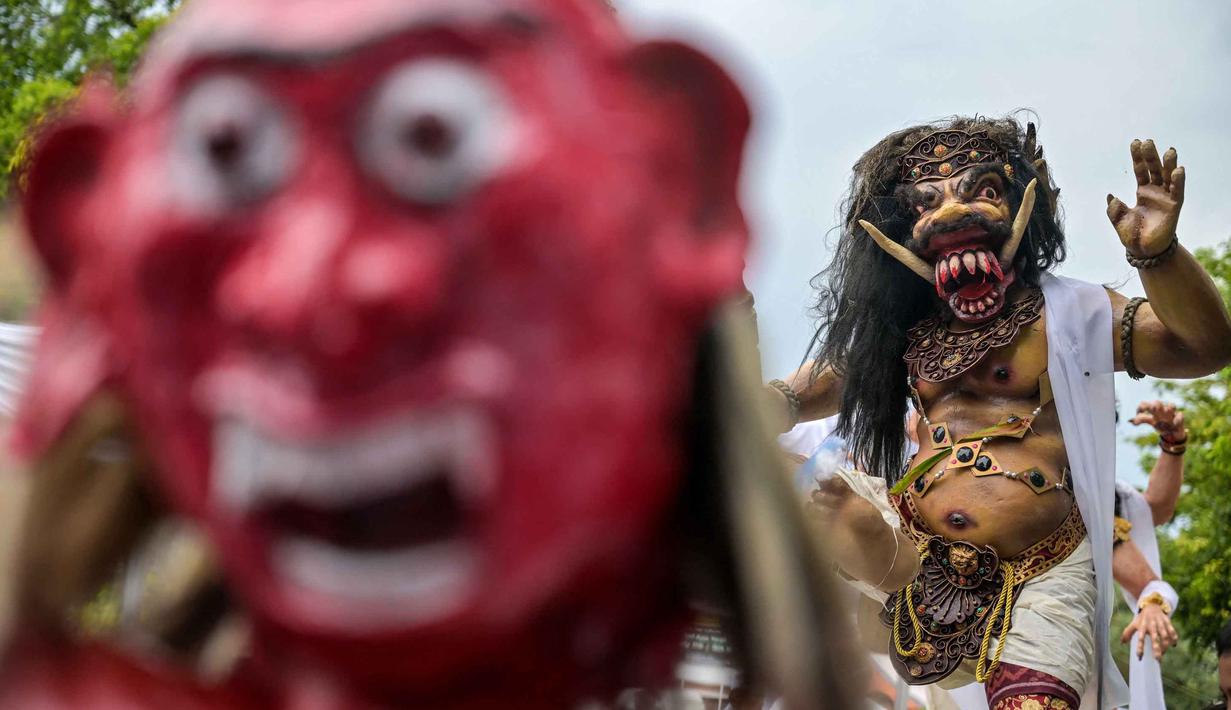 Ogoh-ogoh menjadi ikon ritual utama dalam menyambut Hari Raya Nyepi, khususnya pada hari Pangrupukan (sehari sebelum Nyepi). Tampak dalam foto, para penganut Hindu membawa Ogoh-ogoh, patung yang melambangkan roh jahat, selama pawai menjelang Nyepi di Surabaya pada Rabu 18 Maret 2026. (JUNI KRISWANTO/AFP)