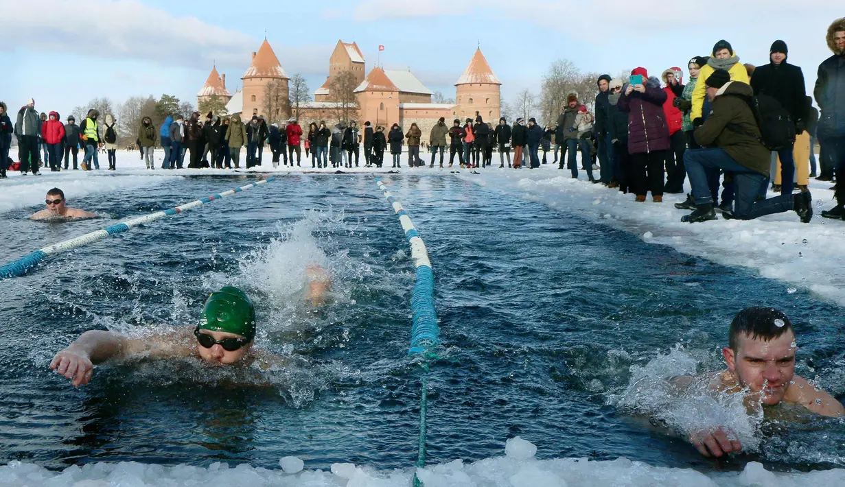 Suasana kompetisi renang musim dingin tahunan dengan air es beku di Trakai, Lituania (24/2). Para peserta tetap antusias mengikuti lomba walaupun dengan suhu di luar hingga minus 12 derajat Celcius. (AFP Photo/Petras Malukas)